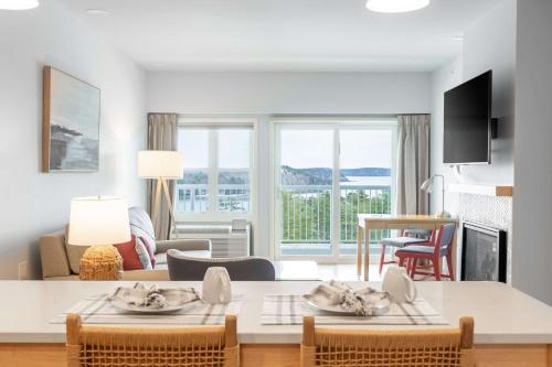a kitchen and living room with a table and chairs at Bluenose Inn - Bar Harbor Hotel in Bar Harbor