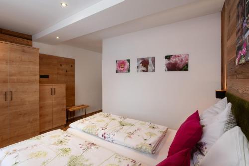 a bedroom with a bed and two pictures on the wall at Ella's in Fusch an der Glocknerstraße