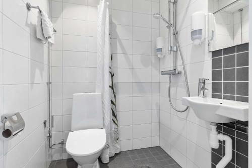 a white bathroom with a toilet and a sink at Best Western Uppsala in Uppsala
