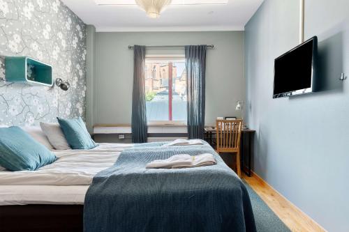 a bedroom with two beds and a flat screen tv at Best Western Uppsala in Uppsala