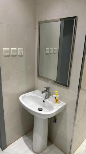 a bathroom with a white sink and a mirror at فيلا مصغره بكراج سياره وفناء خاص in Khamis Mushayt
