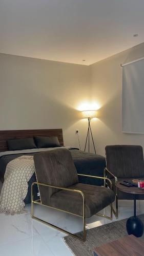 a bedroom with a bed and a couch and a table at فيلا مصغره بكراج سياره وفناء خاص in Khamis Mushayt