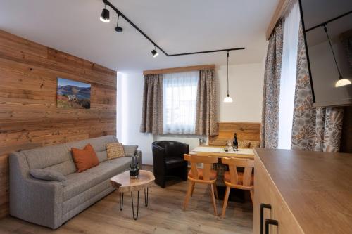 salon z kanapą i stołem w obiekcie Ella's w mieście Fusch an der Großglocknerstraße