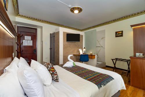 a bedroom with a white bed and a television at Friends Hotel & Rooftop - Historic Center & Museums in Quito