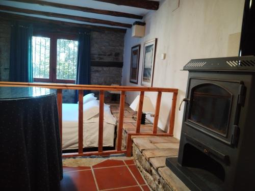 a room with a wood stove and a bedroom at Casa Juez in Ascaso
