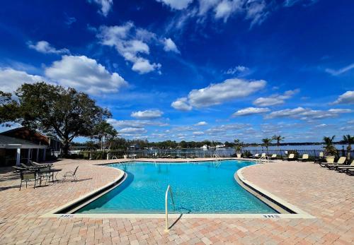 a swimming pool with chairs and a blue sky at Beautiful Condo Close to Busch Gardens in Tampa