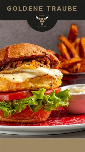 a chicken sandwich on a plate with french fries at VILLA NAJ in Termeno