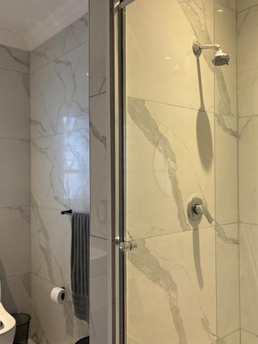 a shower with a glass door in a bathroom at Serene Lonehill in Sandton