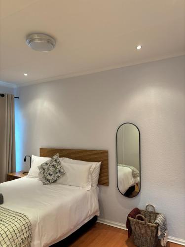 a bedroom with a bed and a mirror on the wall at Serene Lonehill in Sandton