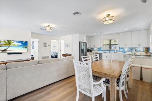 a kitchen and living room with a table and a couch at Gulf Access, Heated Pool & Spa, Tiki Hut - Roelens in Fort Myers Beach