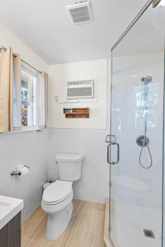 a bathroom with a toilet and a glass shower at Gulf Access, Heated Pool & Spa, Tiki Hut - Roelens in Fort Myers Beach