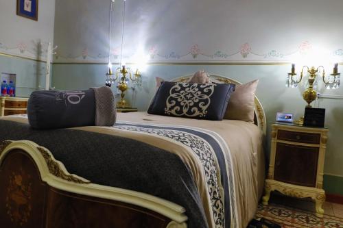 a bedroom with a large bed with blue pillows at Azcami Boutique Hotel in Puebla