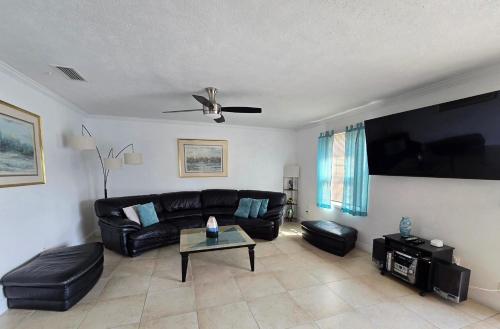 a living room with a black leather couch and a flat screen tv at Beautiful Condo Close to Busch Gardens in Tampa