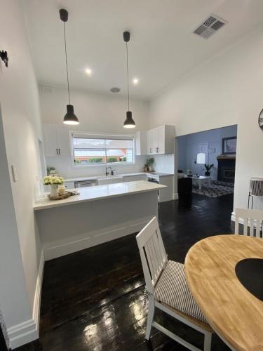 a kitchen and dining room with a table and a counter at Daisy Cottage, 4 bedrooms, close to CBD in Golden Square