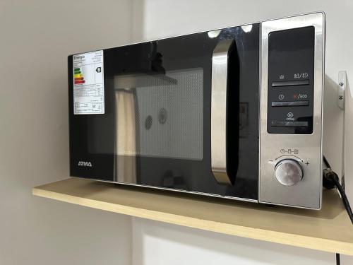 eine Mikrowelle auf einem Regal in einer Küche in der Unterkunft Departamento Centro - San Miguel De Tucumán in San Miguel de Tucumán