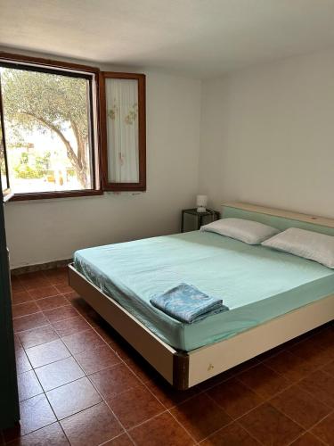 a bed in a bedroom with a large window at Villaliana in Torre Dei Corsari