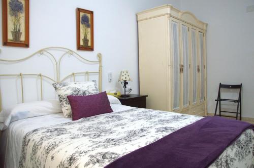 a bedroom with a large bed and a chair at Piso vacacional en Sanlúcar in Sanlúcar de Barrameda