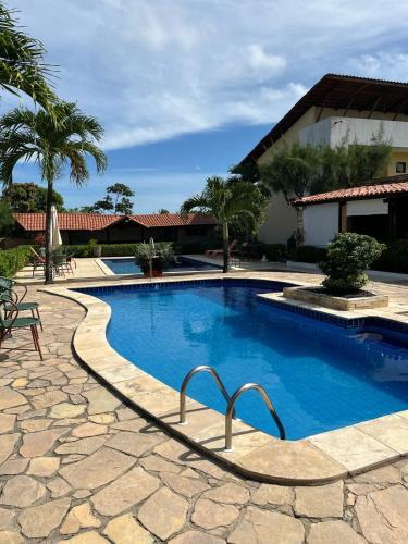 a swimming pool in front of a house at Pousada Aconchego in Pitimbu