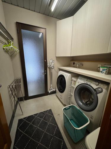 a laundry room with a washing machine and a washer at Bears Den Mountain Lodge in Hakuba