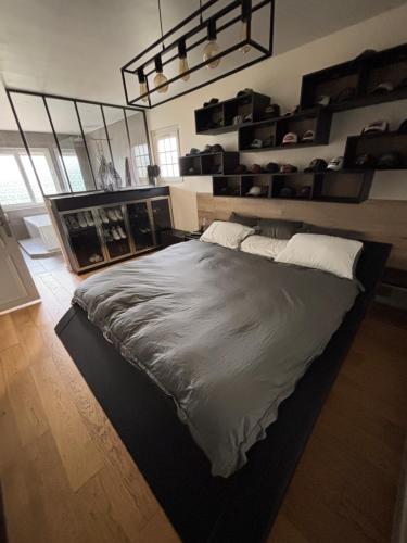 une chambre avec un grand lit dans une pièce dans l'établissement Villa Le Leard, à Allonnes