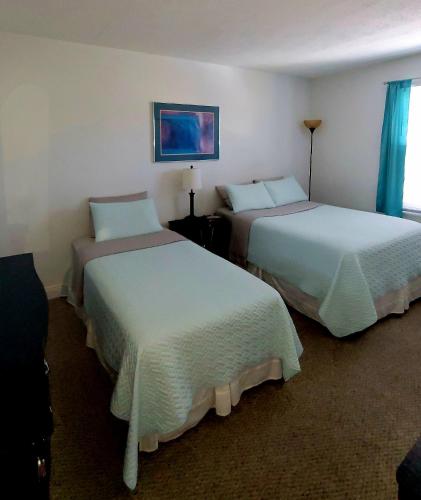 a hotel room with two beds and a tv at Beautiful Condo Close to Busch Gardens in Tampa