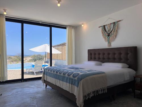 a bedroom with a bed and a view of a pool at Casa Illari- Casa de playa en Vichayito by WiroHouse in Vichayito