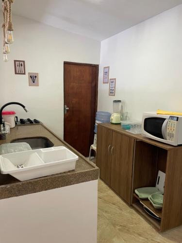 a kitchen with a sink and a microwave at Casa do Lago Sairé in Sairé