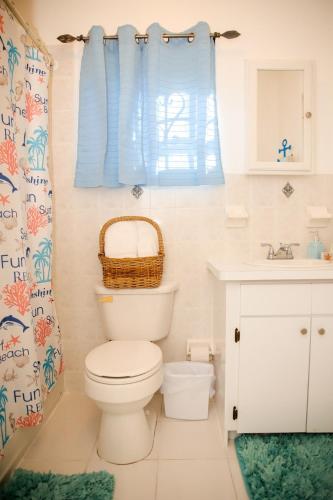 a bathroom with a toilet and a sink at Tangerine Sunsets Skylark in Nassau