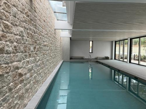 - une piscine dans un bâtiment avec un mur en briques dans l'établissement Beg Leguer T2, trebeurden, à Trébeurden