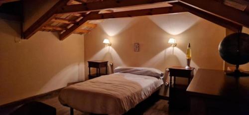 a bedroom with a bed and two lights on the wall at El Granero de Manzanares in Manzanares