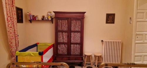 a room with a wooden cabinet and a crib at El Granero de Manzanares in Manzanares