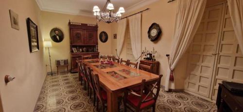 a dining room with a table and chairs and a clock at El Granero de Manzanares in Manzanares