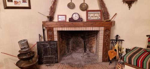 a living room with a fireplace with a clock on it at El Granero de Manzanares in Manzanares