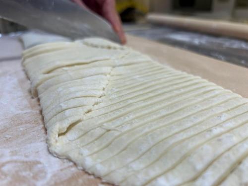a person is kneading a piece of pizza dough at 農家民宿河西園 in Takamatsu