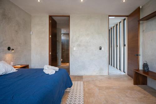 a bedroom with a blue bed and a hallway at Casa en San Benito a steps away from the beach in San Benito