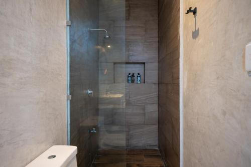a shower with a glass door in a bathroom at Casa en San Benito a steps away from the beach in San Benito