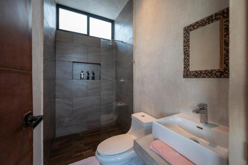 a bathroom with a shower and a toilet and a sink at Casa en San Benito a steps away from the beach in San Benito