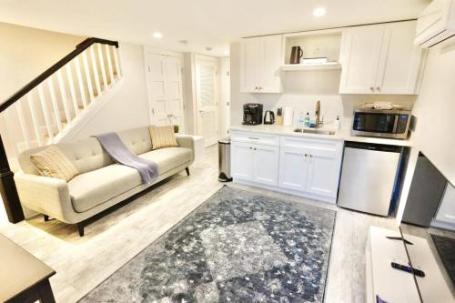 a living room with a couch and a kitchen at Lovely English Basement Apartment in Washington DC in Washington, D.C.