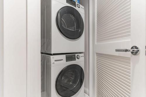 two washer and dryer in a room next to a door at Lovely English Basement Apartment in Washington DC in Washington, D.C.