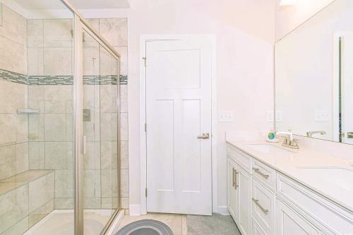 a white bathroom with a shower and a sink at Family Fun House At Barefoot Resort & Golf in North Myrtle Beach