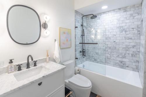 a bathroom with a sink and a toilet and a mirror at Luxury DuPont Apartment in the heart of DC in Washington