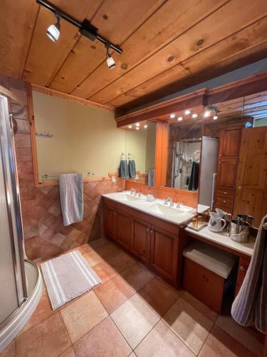 a large bathroom with a sink and a mirror at Entre Pierre et Bois, couette et café in Lac-Superieur
