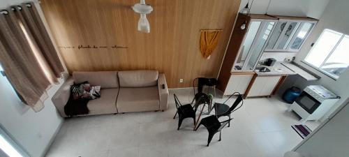 a person sitting on a couch in a living room at casa ipê sobrado Pindamonhangaba, Moreira César in Pindamonhangaba