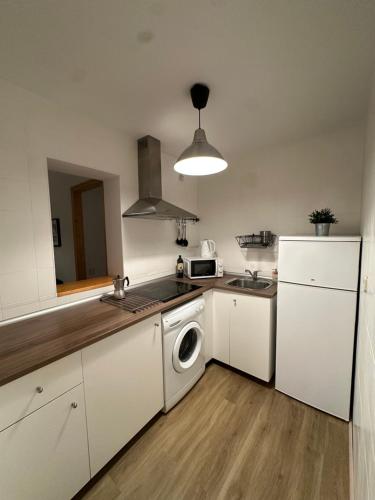 a kitchen with a white refrigerator and a washing machine at Madrid Room Sol Center in Madrid