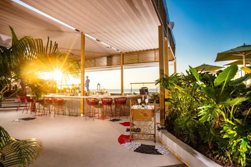 a patio with a table and chairs and plants at Almar LGBT Luxury Resort in Puerto Vallarta