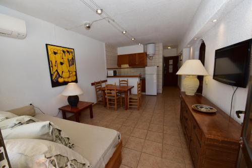 a bedroom with a bed and a living room with a kitchen at Costamar 13 in Es Pujols