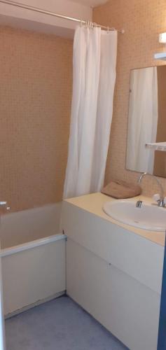 une salle de bain avec un lavabo, une baignoire et un miroir dans l'établissement Bel apartment Gruissan, à Gruissan