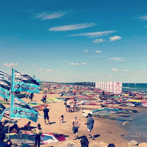 un groupe de personnes sur une plage avec des cerfs-volants dans l'établissement Bel apartment Gruissan, à Gruissan