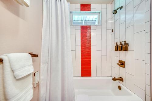 a bathroom with a white shower curtain and a tub at Rainforest Stay with Hot Tub Less Than 3 Mi to Natl Park! in Volcano