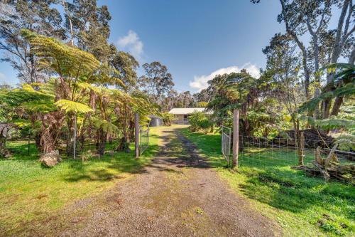 a dirt road in a field with trees and a fence at Rainforest Stay with Hot Tub Less Than 3 Mi to Natl Park! in Volcano